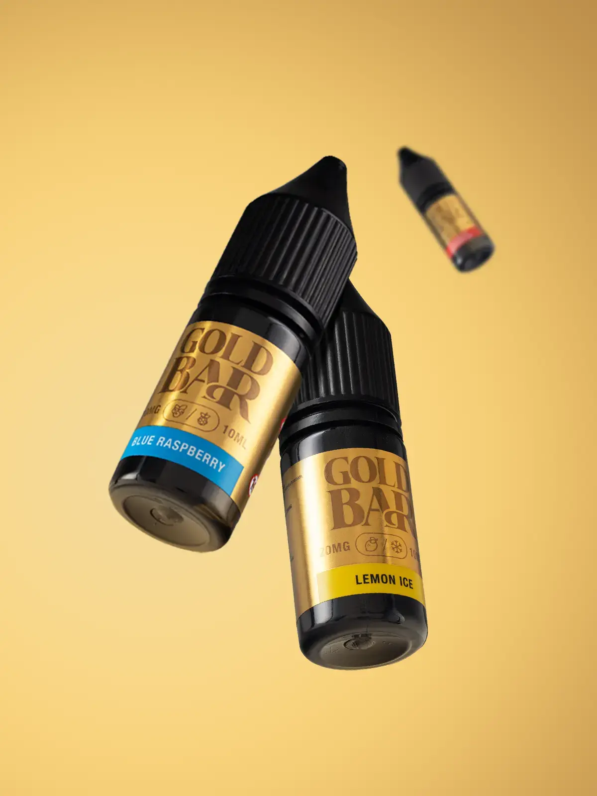 Three Gold Bar e-liquids including Blue Raspberry and Lemon Ice flavours, floating in front of a gold coloured background