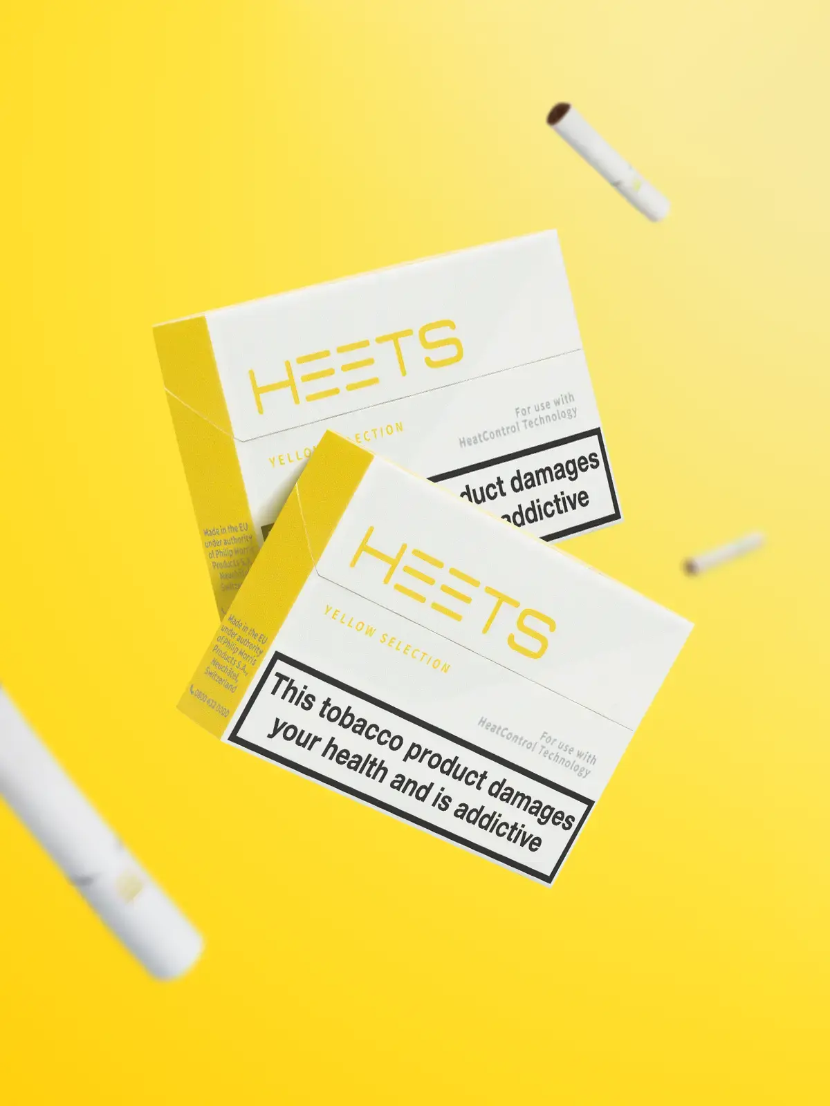 Two packs of IQOS Yellow HEETS floating in front of a bright yellow background