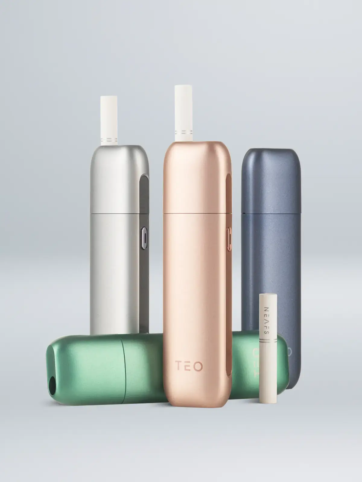 Four NEAFS Teo devices in Titanium Grey, Blue, Green and Rose Gold along with a single NEAFS stick, standing in front of a light background